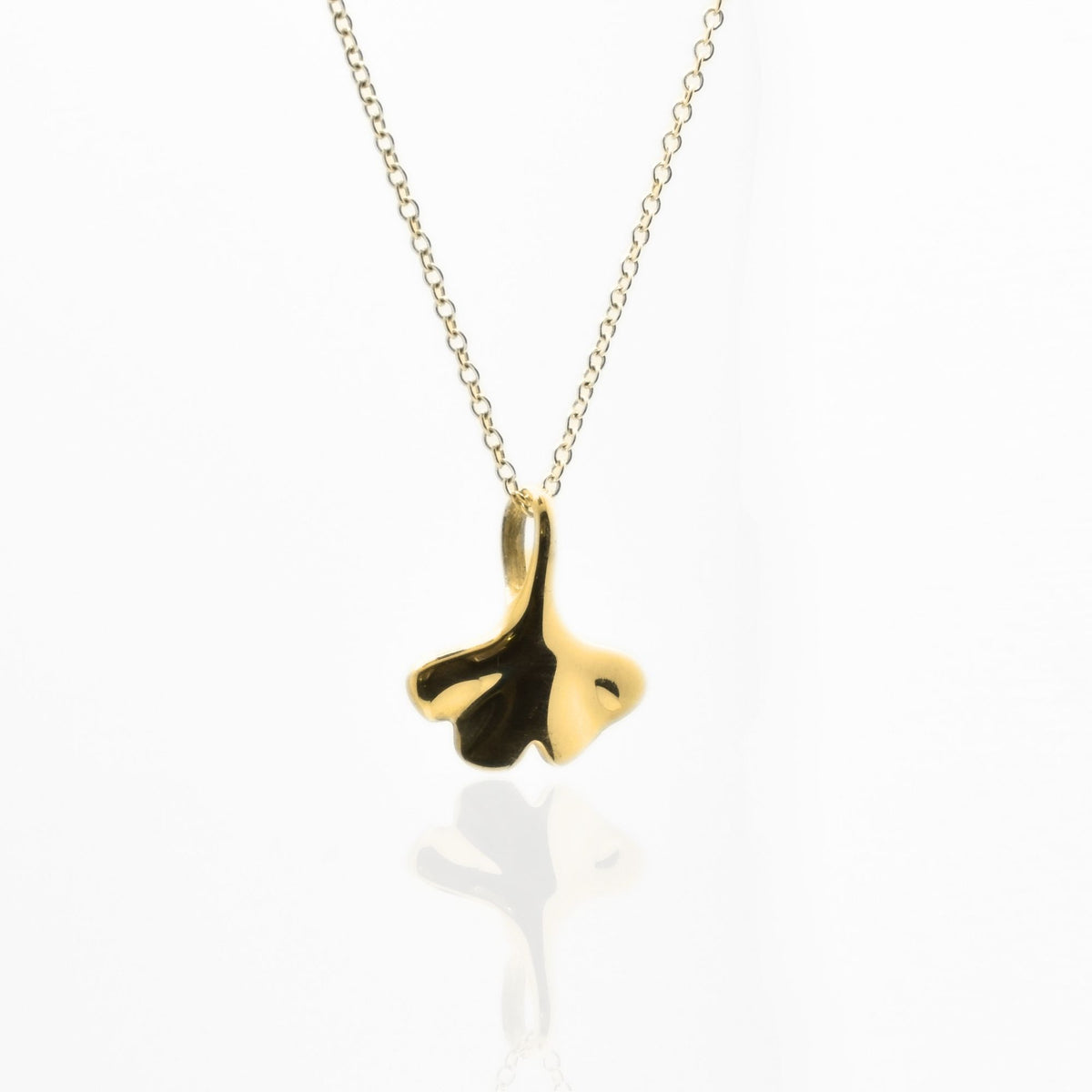 Dynamic studio perspective of the Botanical Ginkgo Leaf Pendant 14mm petite in 18k yellow gold, showcasing master metalwork and fluid symmetry by Gina Rose Atelier.