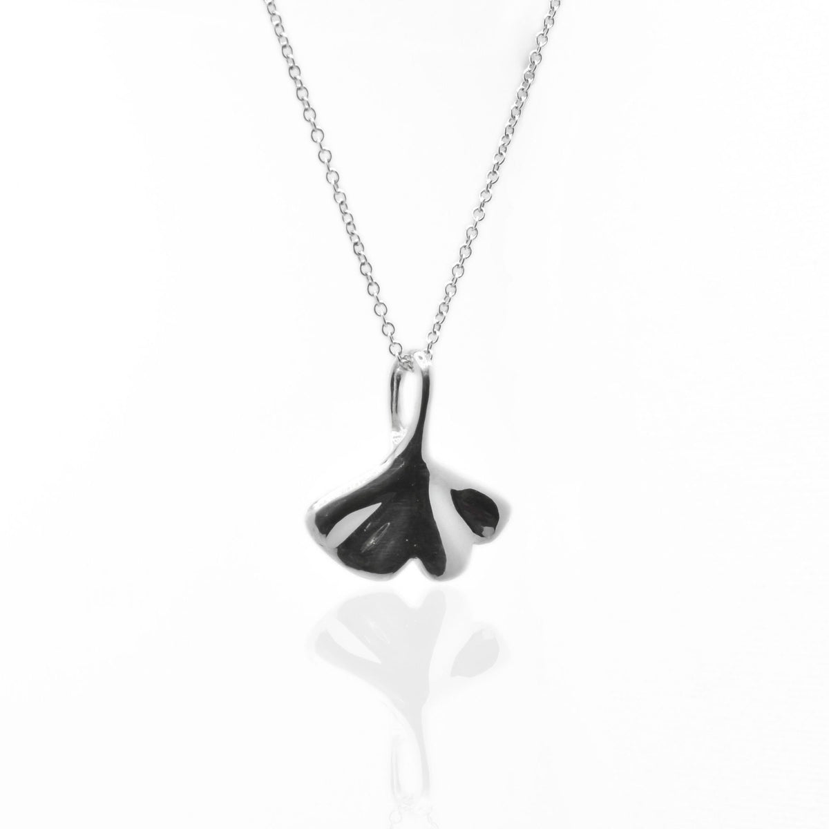 Dynamic studio perspective of the Botanical Ginkgo Leaf Pendant 20mm in solid sterling silver, showcasing master metalwork and fluid symmetry by Gina Rose Atelier.