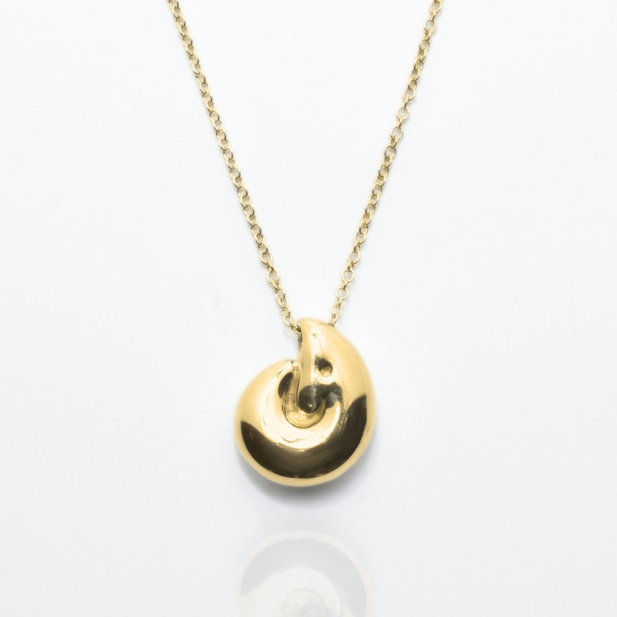 Dynamic studio perspective and mirror reflection of the Pelagic Nautilus Pendant 14mm grande in solid 18k yellow gold by Gina Rose Atelier.