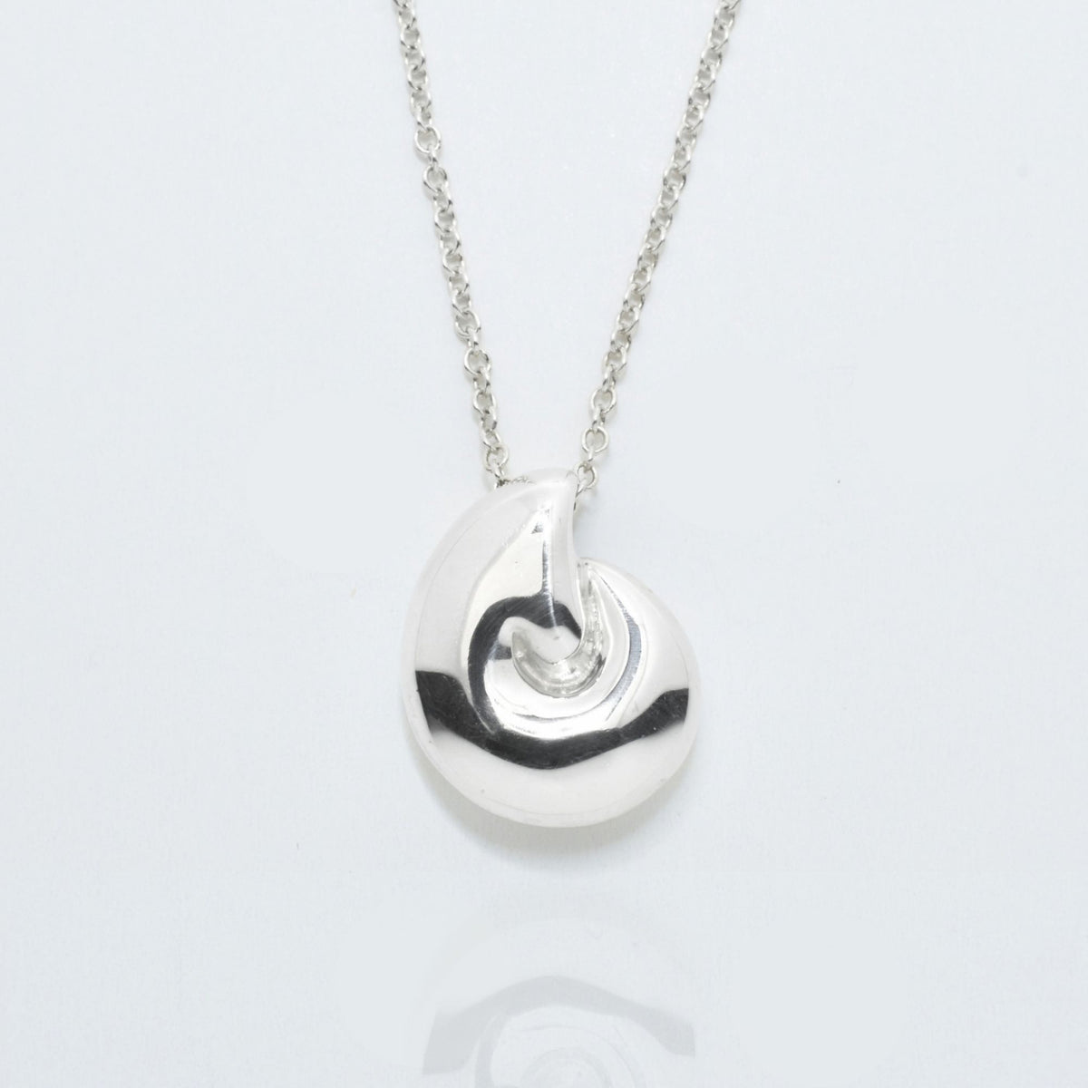 The Pelagic Nautilus Pendant in 14mm grande scale crafted in solid sterling silver by Gina Rose Atelier, shown with a mirror studio reflection on a custom silver chain.