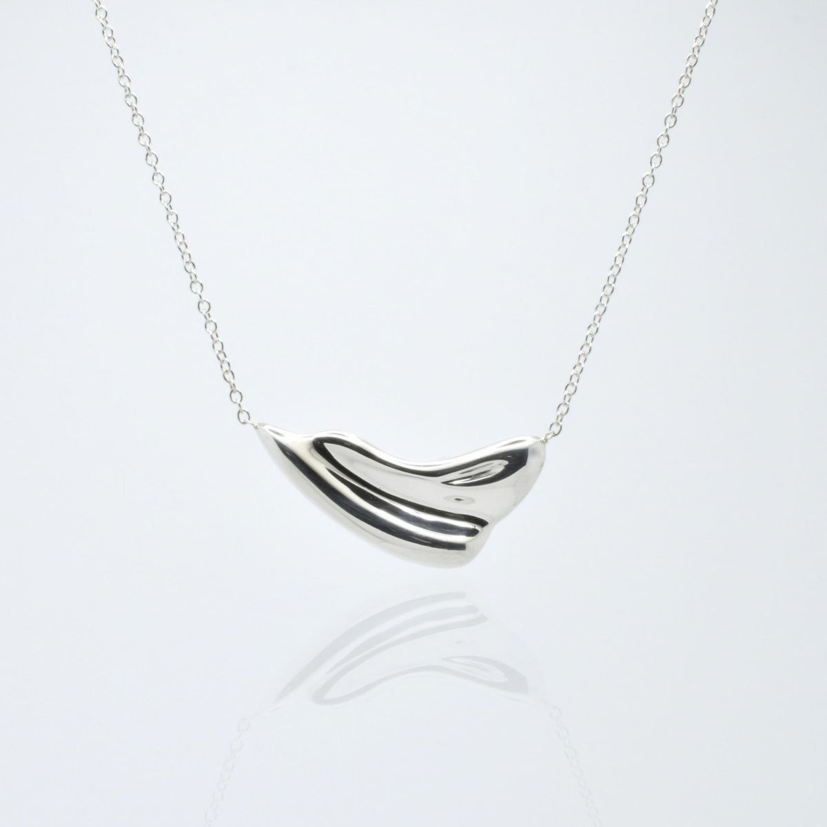 Dynamic studio perspective and mirror reflection of the Pelagic Wave Pendant 24mm grande in solid sterling silver by Gina Rose Atelier