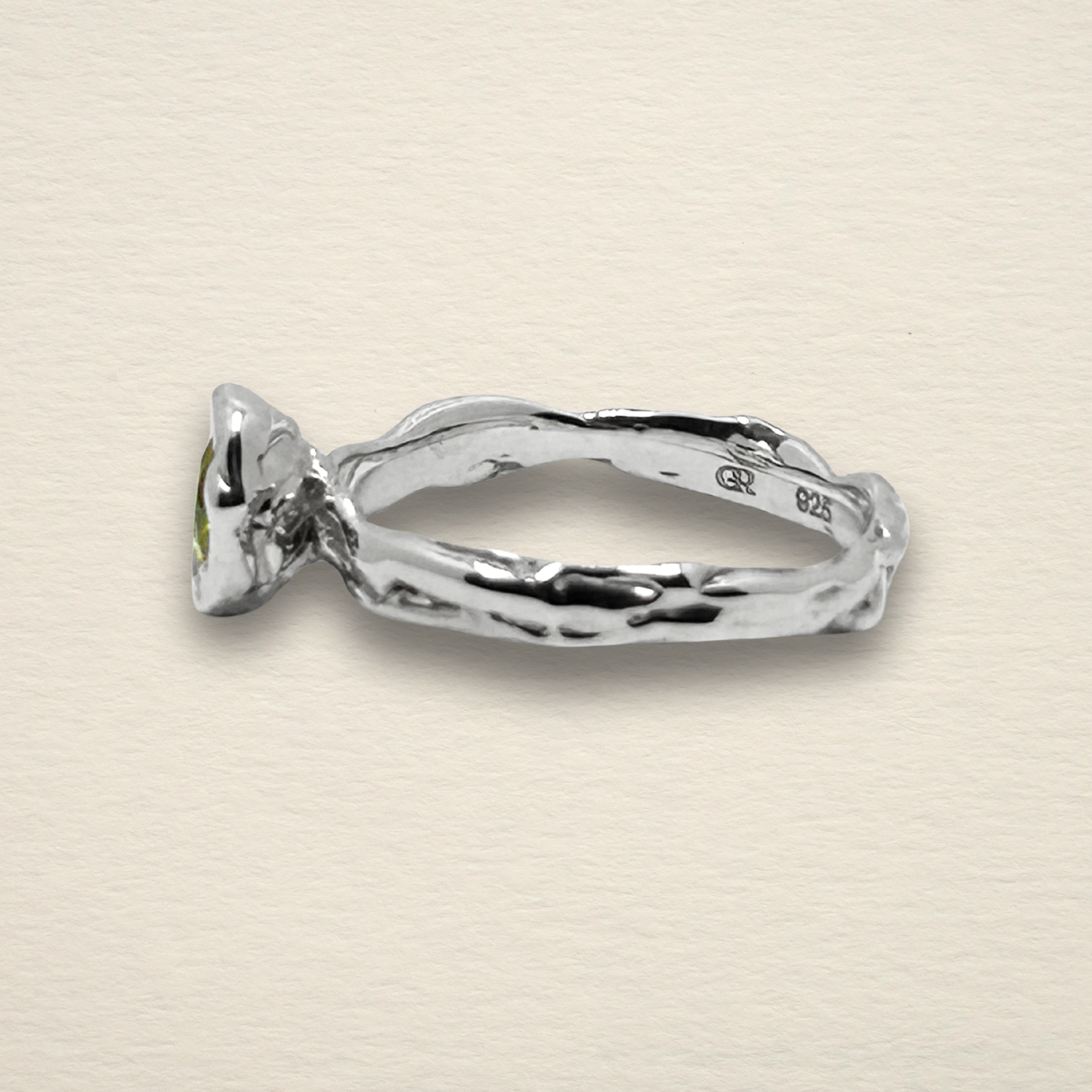 Profile view of the Archive Series Peridot Solitaire ring, highlighting the additive wax-sculpted band and the architectural integrity of the hand-refined setting in recycled sterling silver.