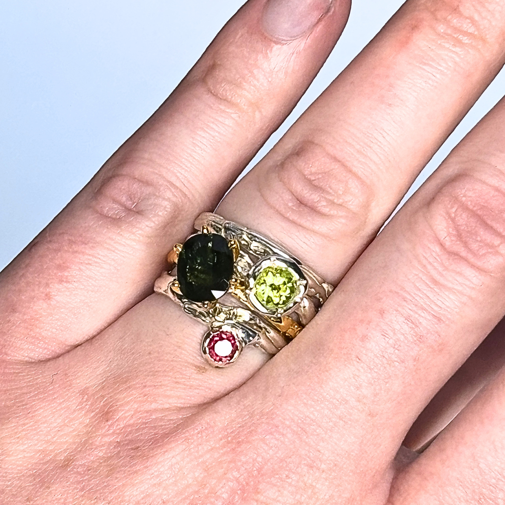 The Archive Series Sculpted Band worn alongside other Archive collection artifacts, emphasizing the tactile, organic texture and master-goldsmithing quality of the sterling silver band on the hand.