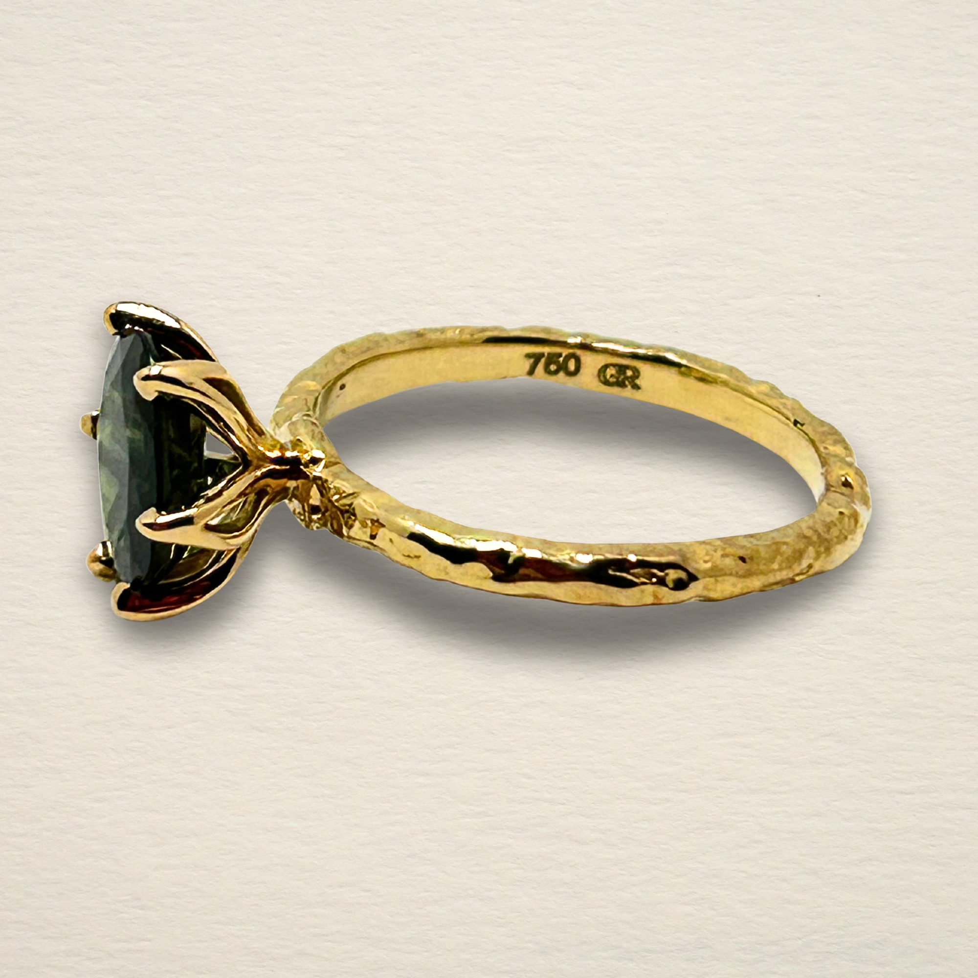 Profile view of the Archive Series Green Sapphire ring, highlighting the bespoke, organic 6-prong setting and the textured, sculpted 18k yellow gold shank.