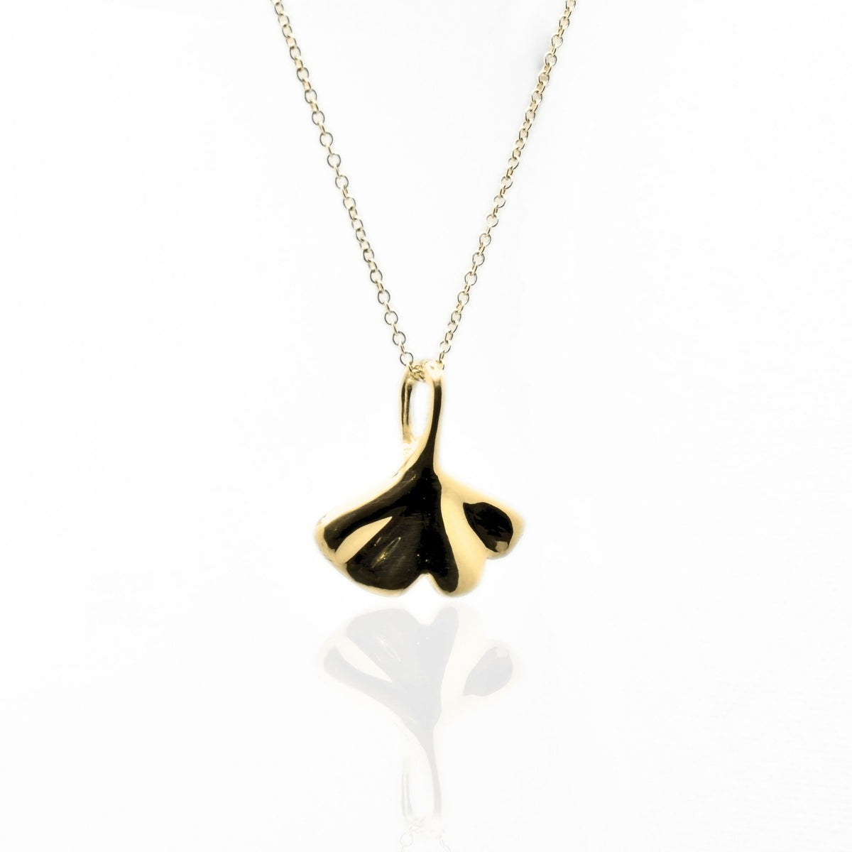 Side-angled view of the Botanical Ginkgo Leaf Pendant 20mm grande in solid 18k yellow gold, illustrating the organic depth and sovereign finish by Gina Rose Atelier.