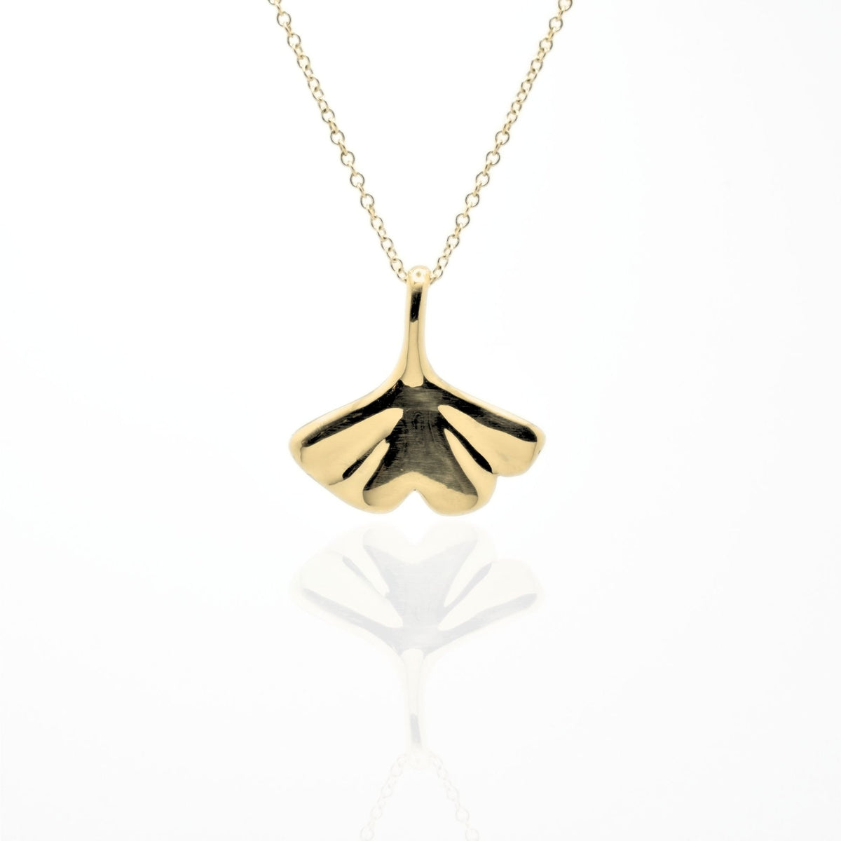 Studio reflection view of the Botanical Ginkgo Leaf Pendant 20mm in solid 18k yellow gold, highlighting the hand-finished fan-shaped architecture from Gina Rose Atelier.