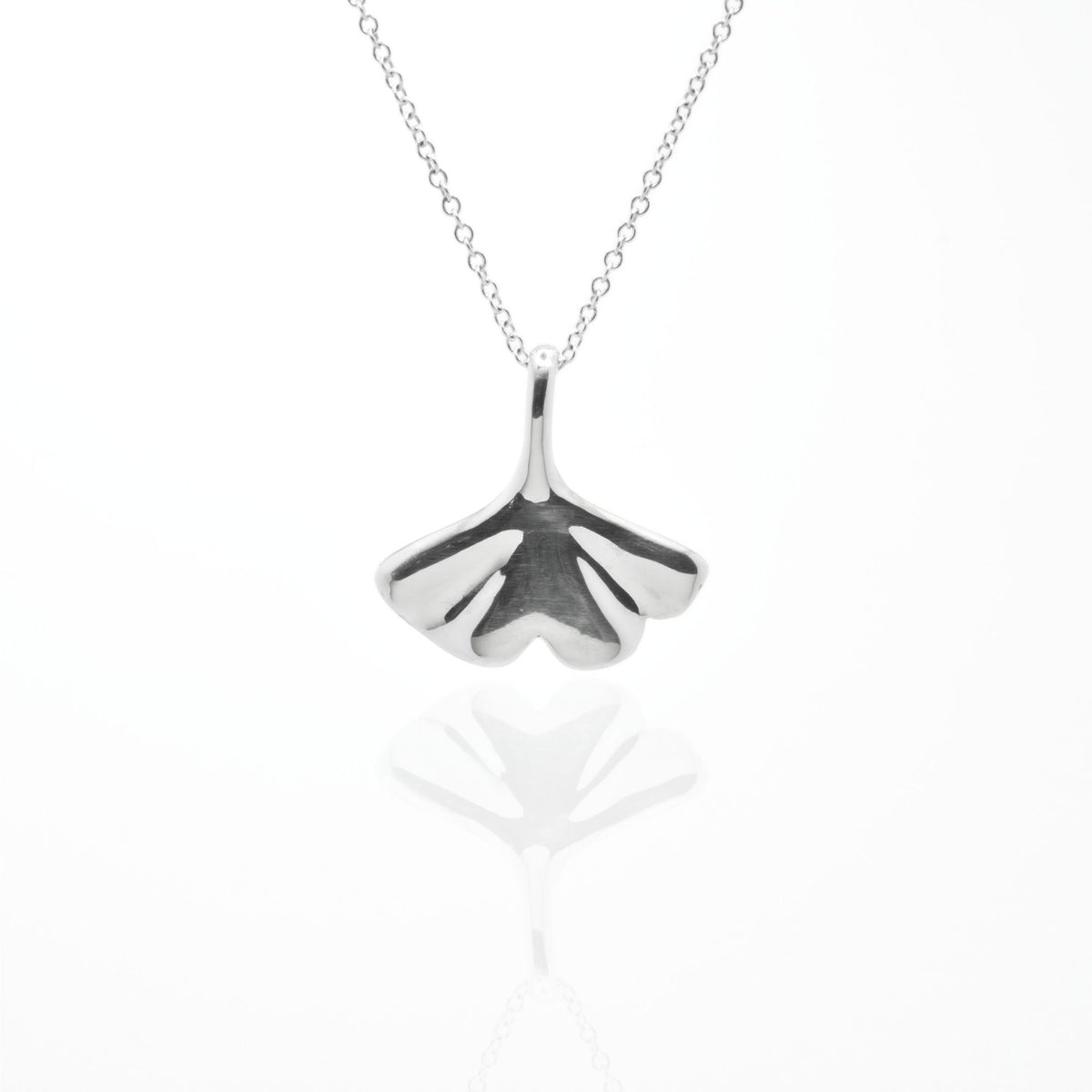 Studio reflection view of the Botanical Ginkgo Leaf Pendant 20mm in solid sterling silver, highlighting the hand-finished architectural contours from Gina Rose Atelier.