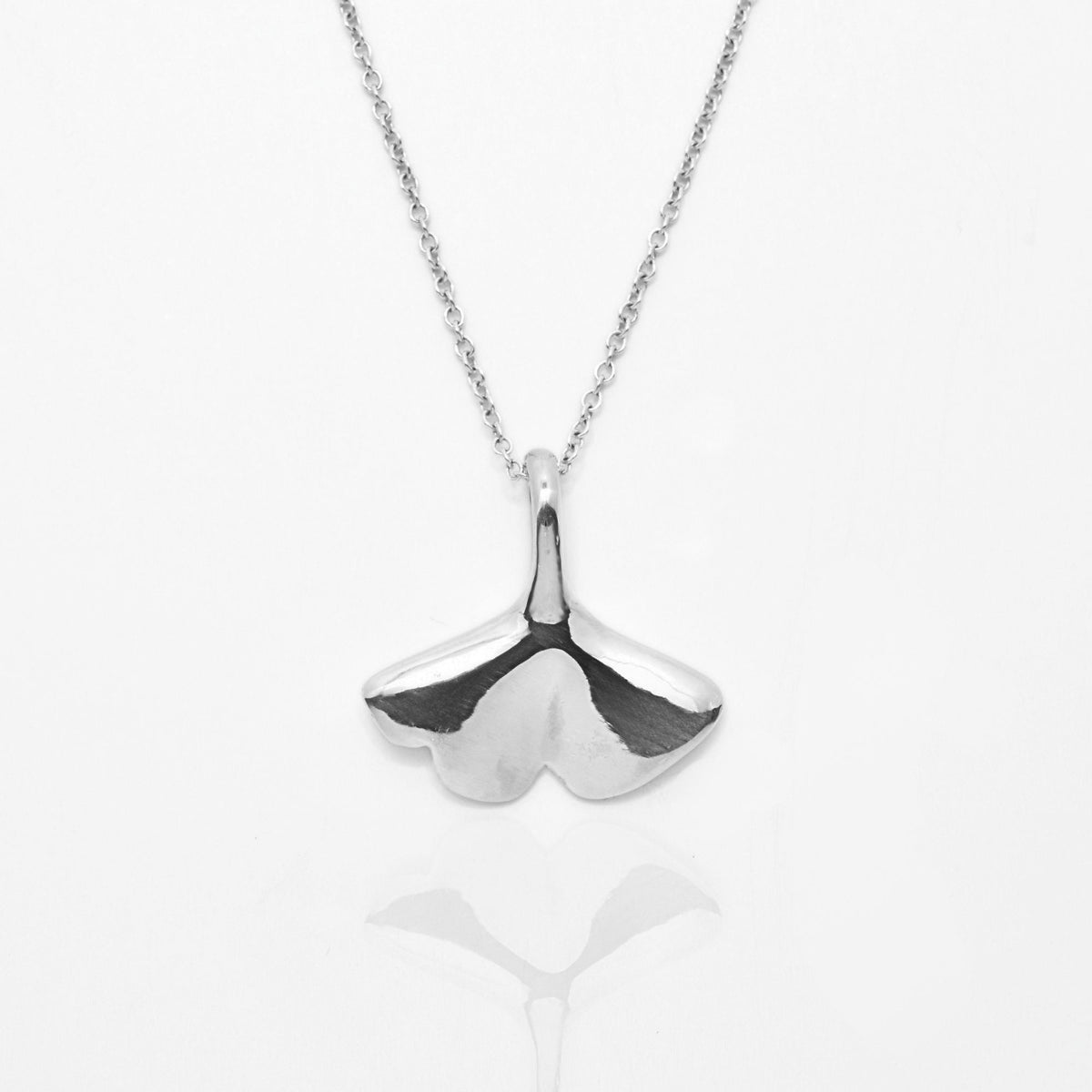 The Botanical Ginkgo Leaf Pendant in 20mm grande scale crafted in solid sterling silver by Gina Rose Atelier, shown with a mirror studio reflection on a custom silver chain.