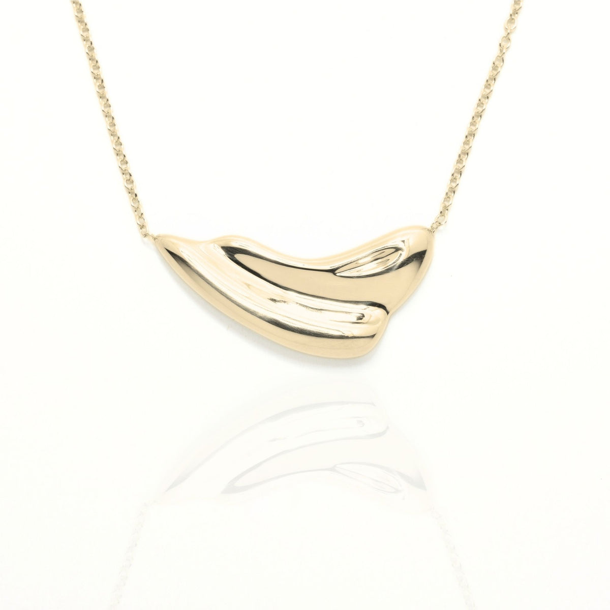 Close-up front view of the Pelagic Wave Pendant 24mm grande in 18k yellow gold, showcasing master-crafted sweeping crest geometry and polished finish by Gina Rose Atelier.