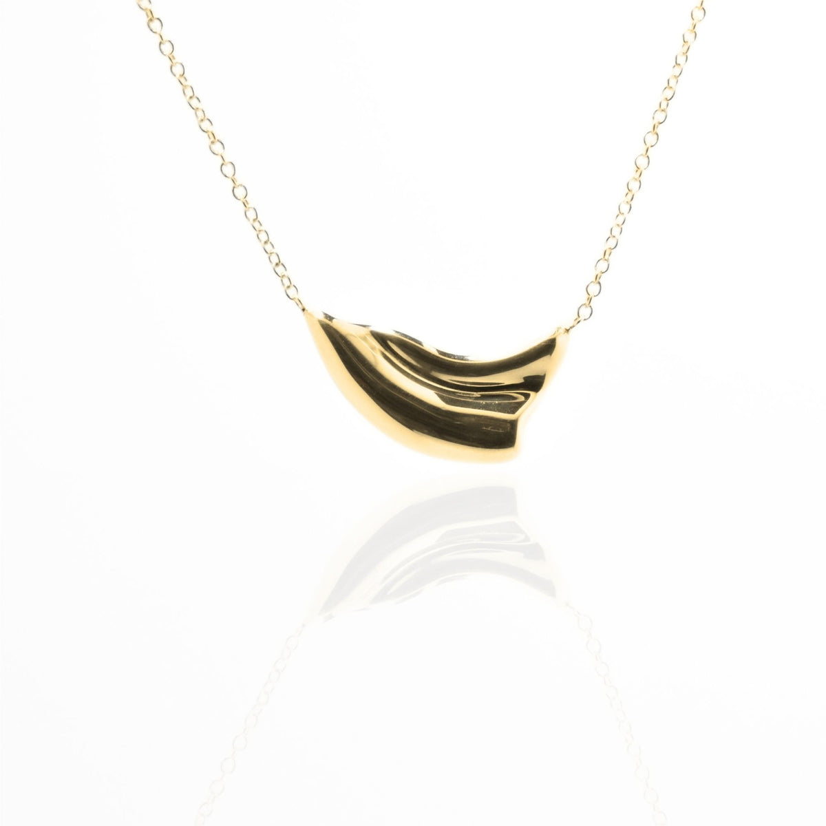 Direct studio front view of the Pelagic Wave Pendant 18mm petite in solid 18k yellow gold, emphasizing tactile volume and fine jewelry craftsmanship.