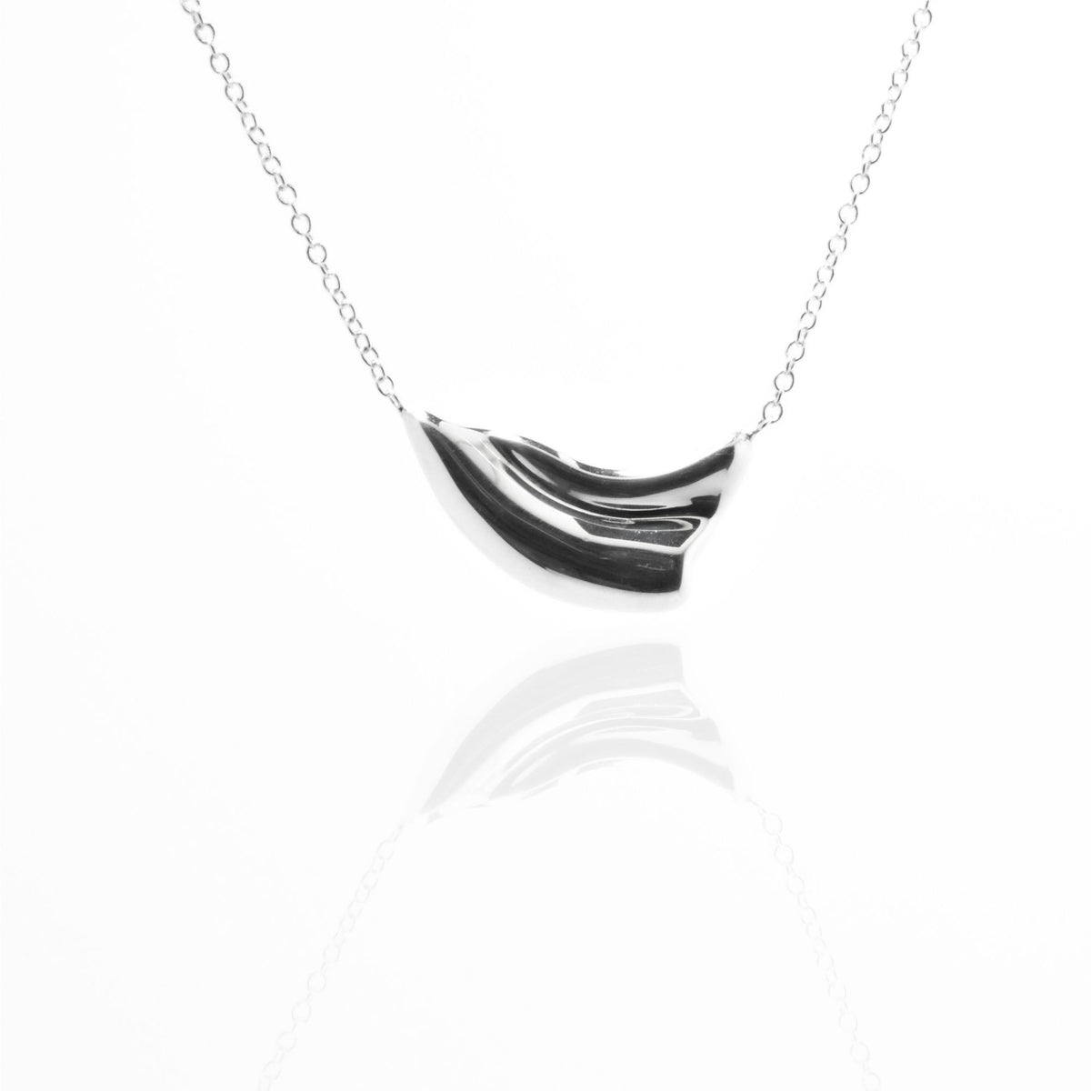 Direct studio front view of the Pelagic Wave Pendant 18mm petite in solid sterling silver, emphasizing tactile volume and fine jewelry craftsmanship