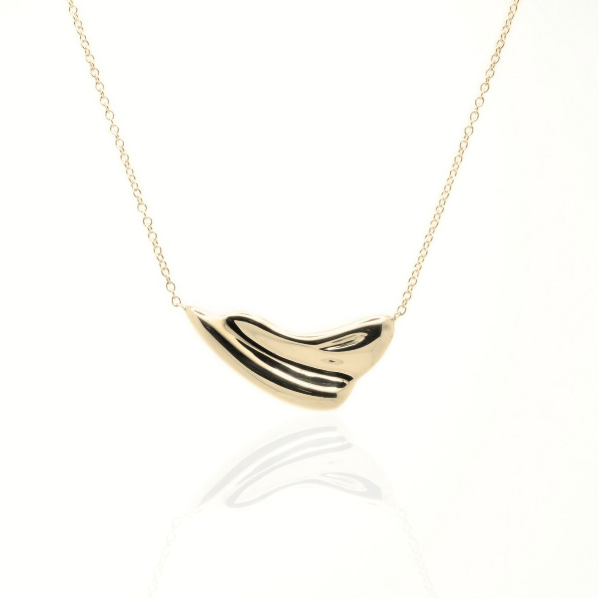 Close-up front view of the Pelagic Wave Pendant 24mm grande in 18k yellow gold, showcasing master-crafted sweeping crest geometry and polished finish by Gina Rose Atelier.