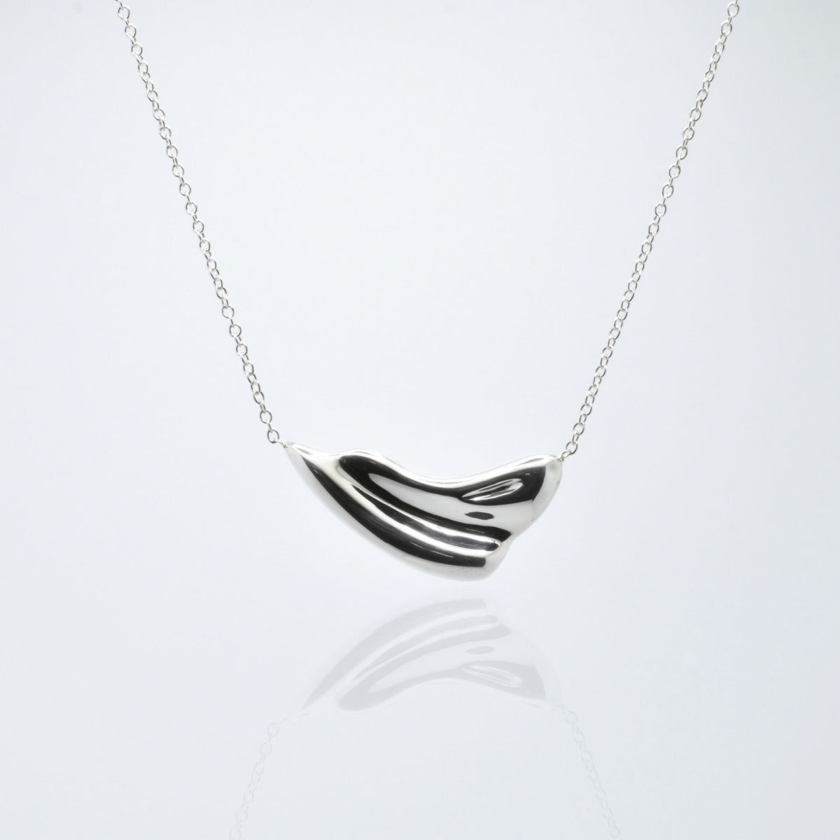 Direct studio front view of the Pelagic Wave Pendant 24mm grande in solid sterling silver, emphasizing tactile volume and fine jewelry craftsmanship